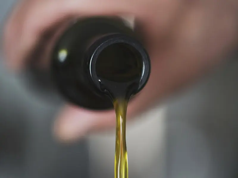 Unser ungefiltertes, naturreines Öl läuft aus der Flasche heraus